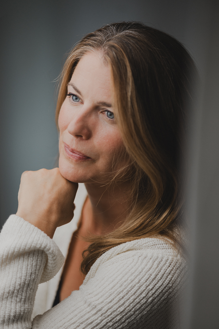 Portrait d'Amandine Englebert, pull crème, menton posé sur la main